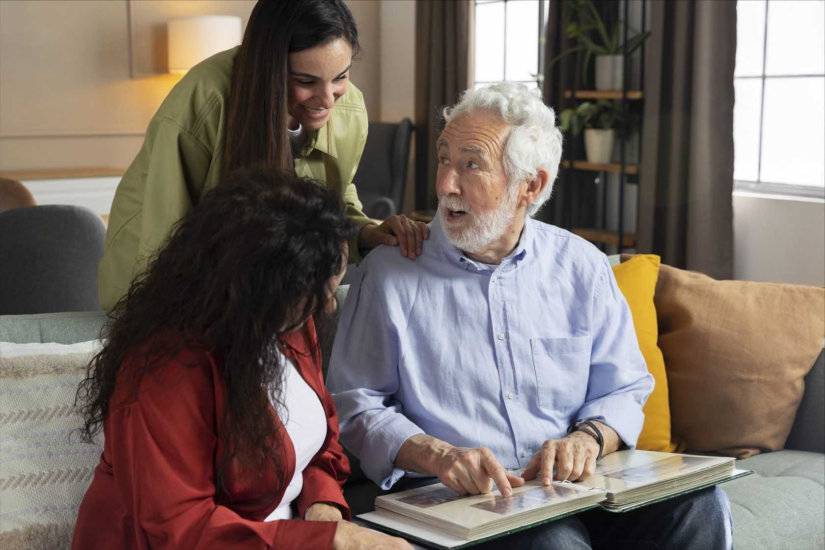 Senior looking at family album with family.