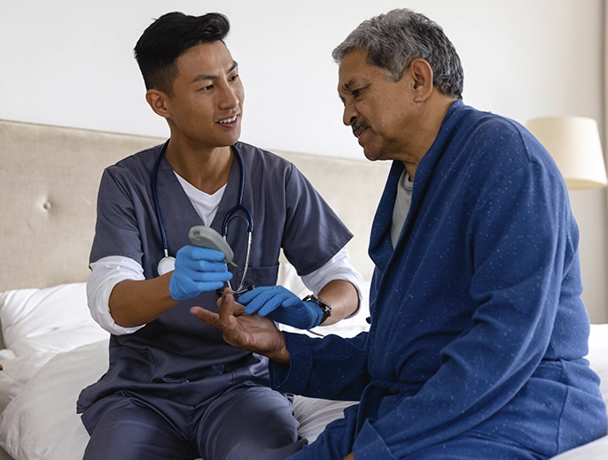 Healthcare provider measuring blood pressure of an elderly man during chronic care management visit.