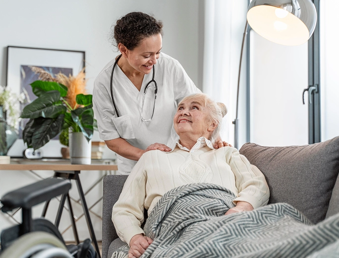 Elderly patient recovering in bed with family member beside