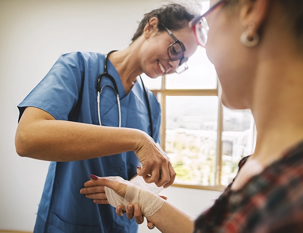Healthcare worker treating chronic wound at patient’s bedside