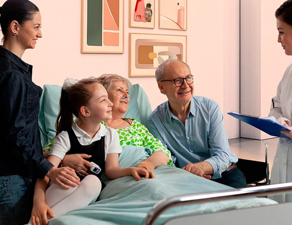 Smiling family caregiver comforting elderly patient at home